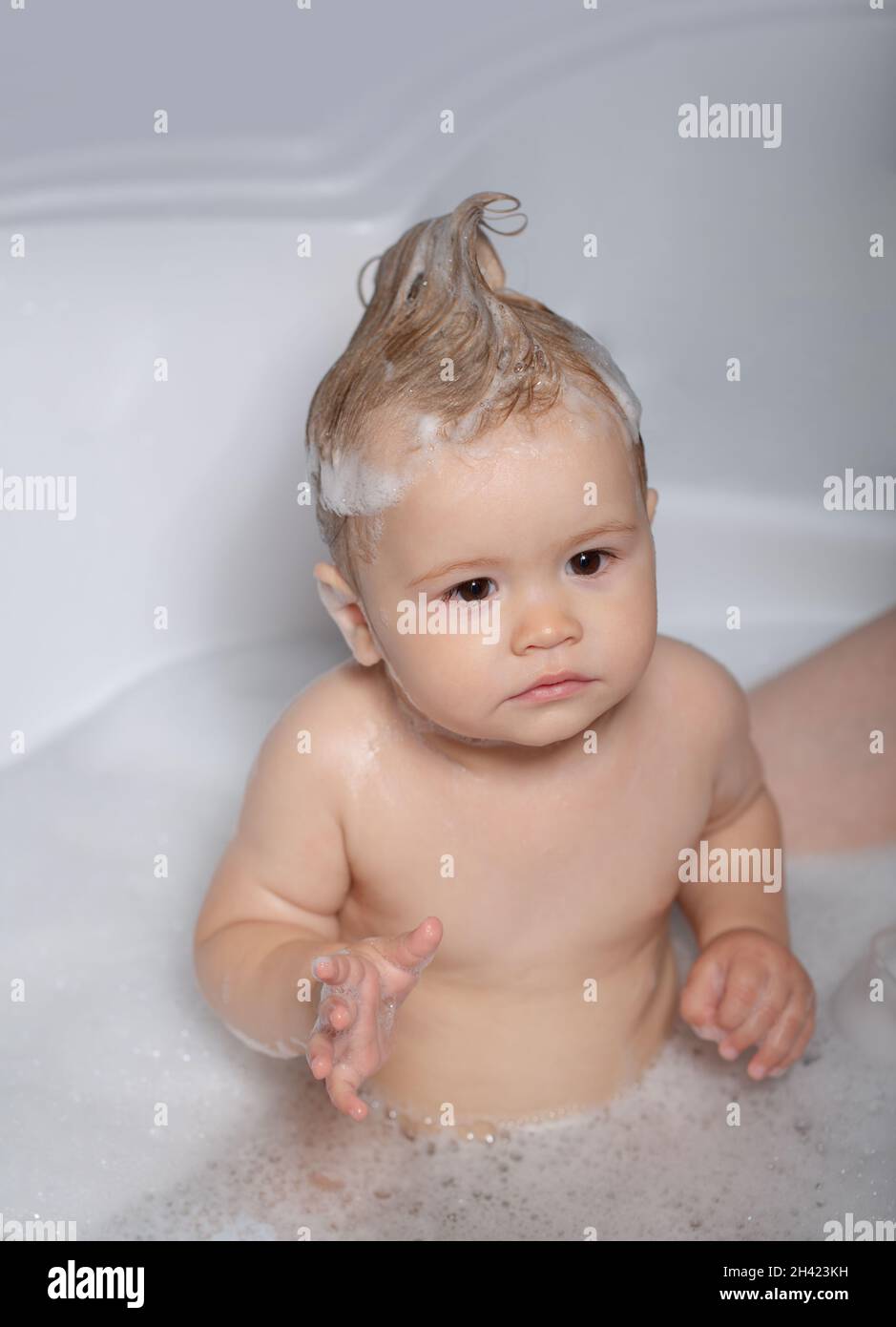 Todler in shower. Little boy in bathtub with fluffy soap bubble. Baby