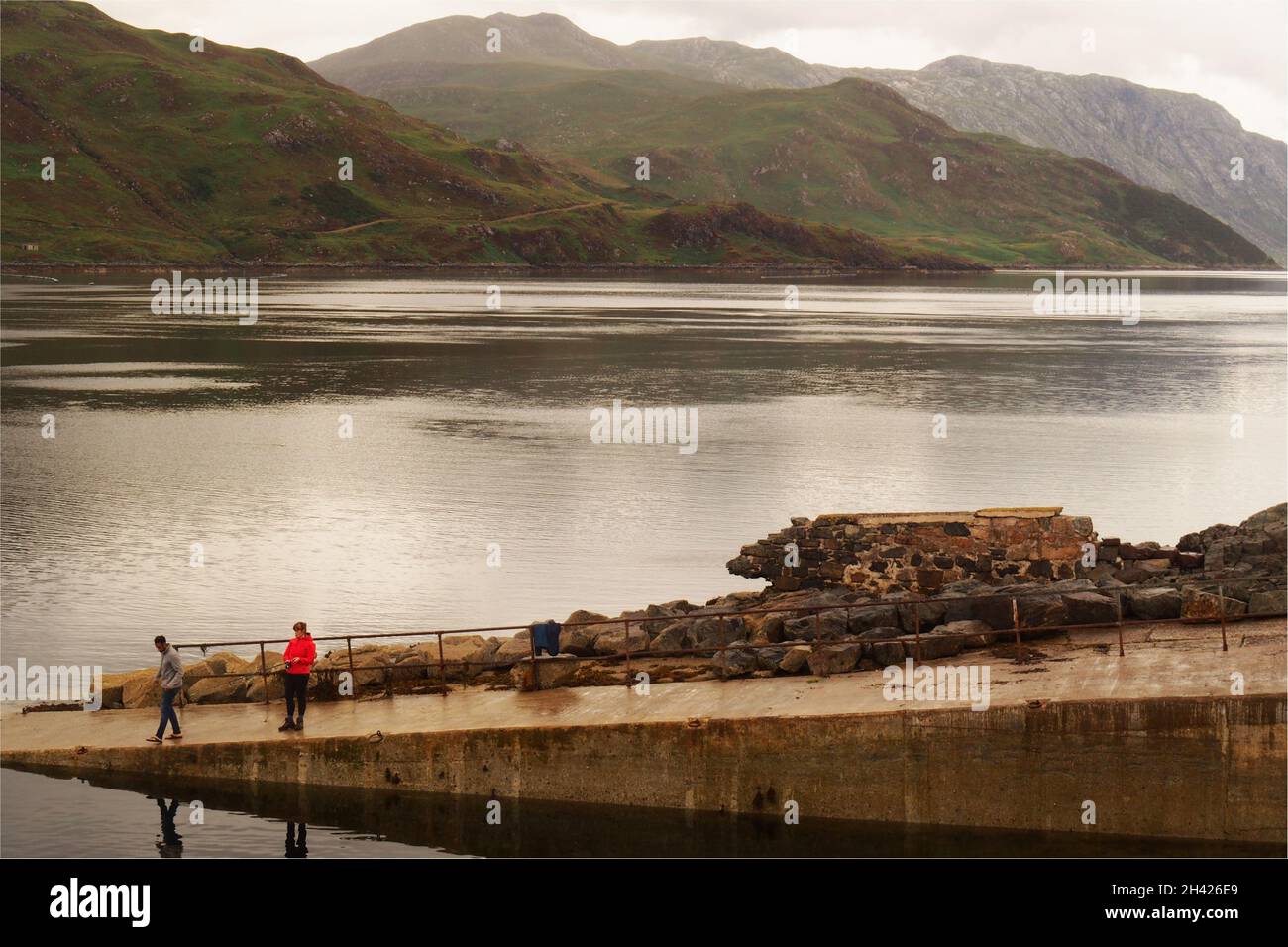 A young man and woman fishing on a slipway at Kylesku pier by Loch Gleann |Dubh, Sutherland, Scotland Stock Photo