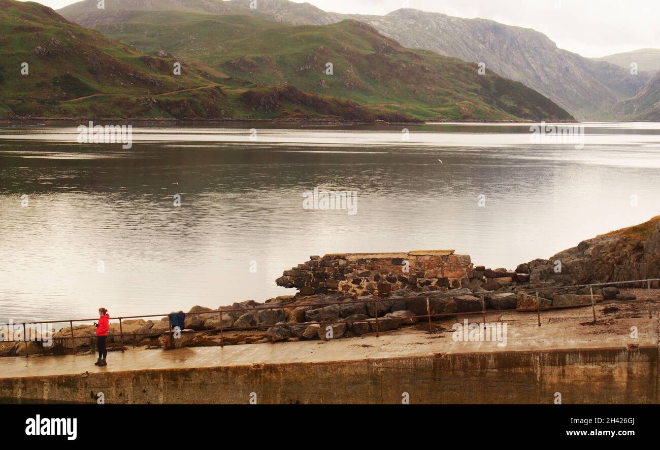 A young woman fishing on a slipway at Kylesku pier, by Loch Gleann Dubh, Sutherland, Scotland Stock Photo