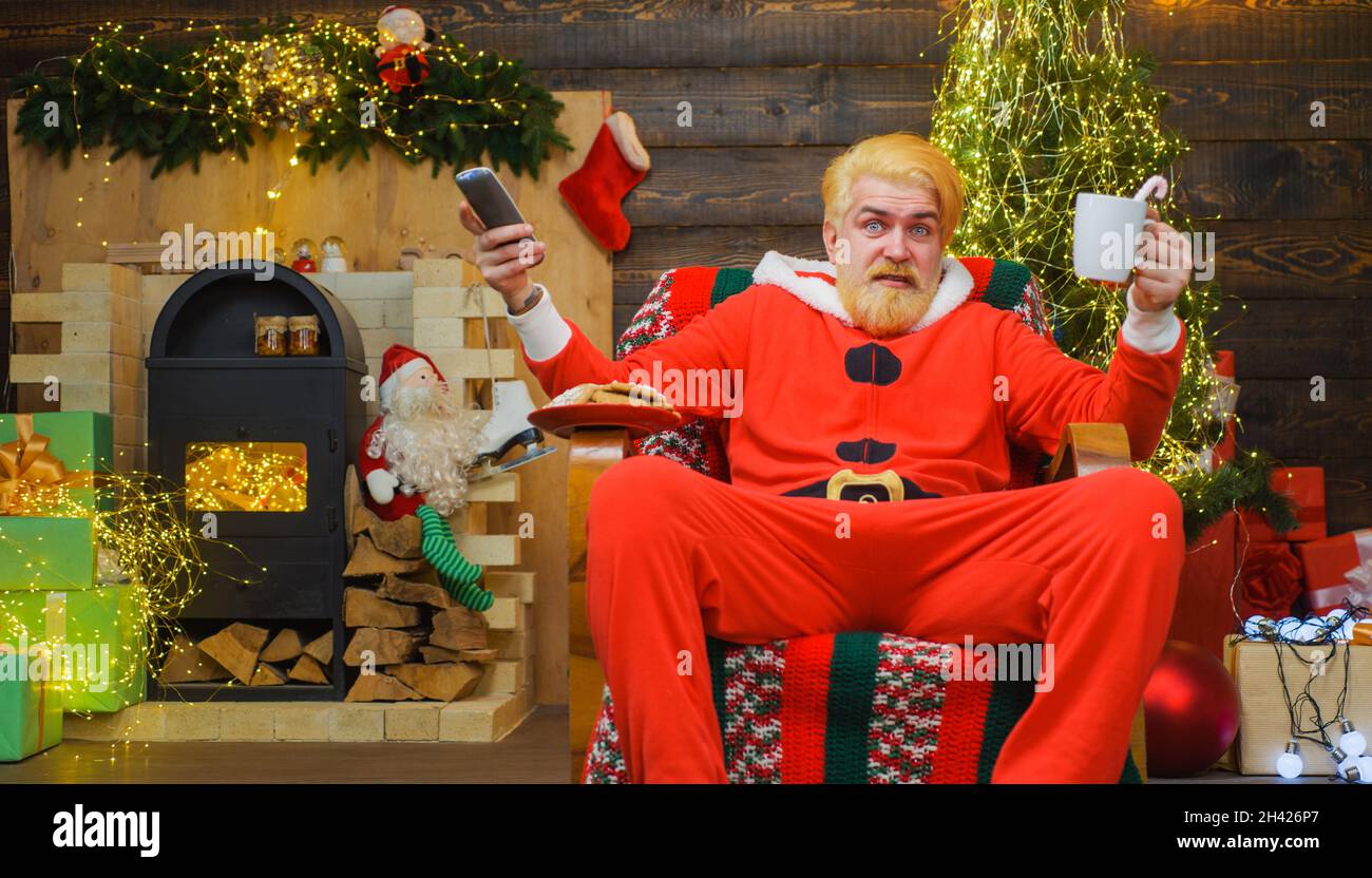 Santa claus sitting in armchair and drinking coffee. Merry christmas. New year advertising. Stock Photo