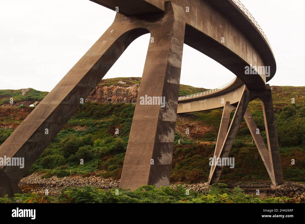 A view of the Kylesku bridge , Sutherland, Scotland, showing its curved shape and huge supports over the Loch Chairn Bhain Stock Photo