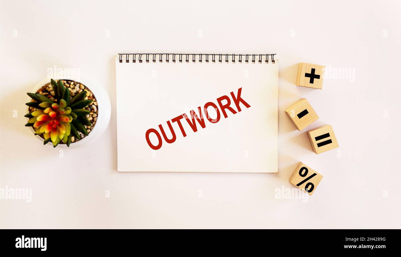 OUTWORK , the text is written on a notebook and a white background. On the table are wooden cubes with signs and there is a cactus flower Stock Photo