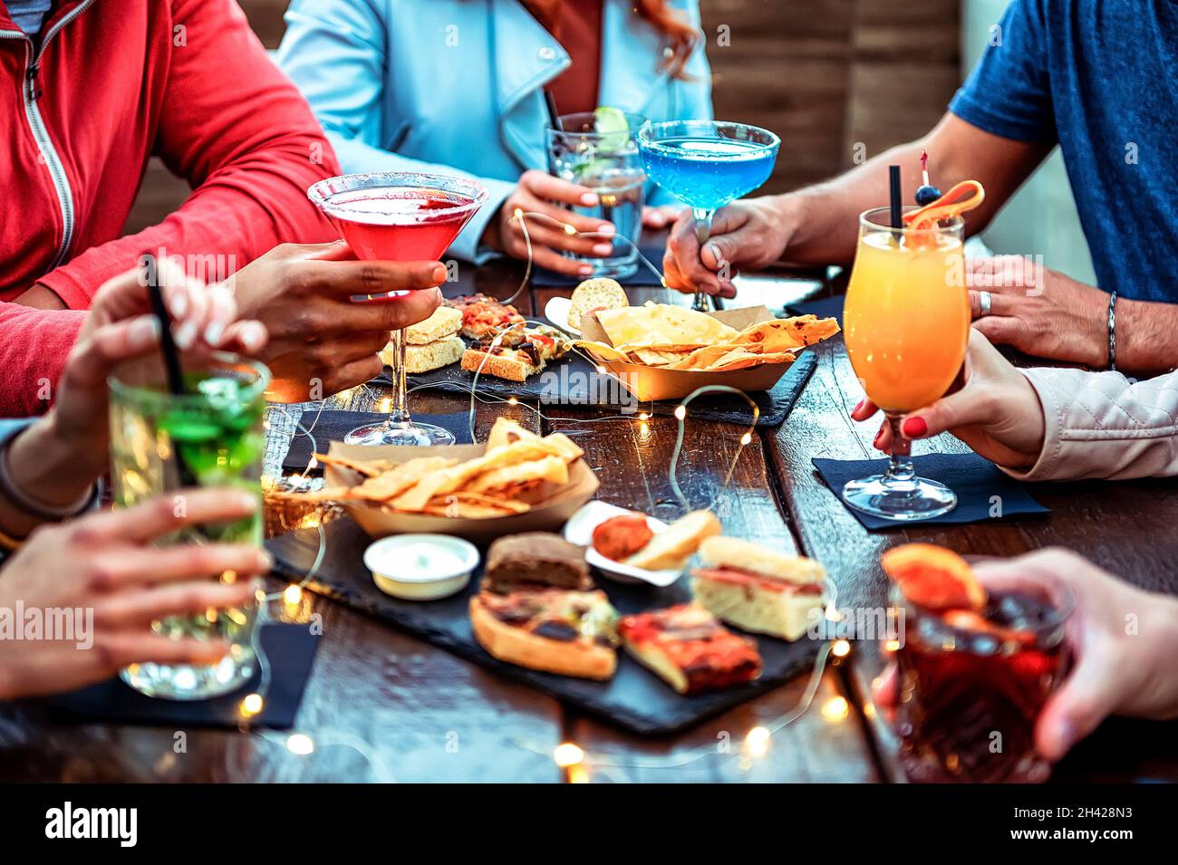 Group of friends enjoying appetizer drinking and eating in a bar
