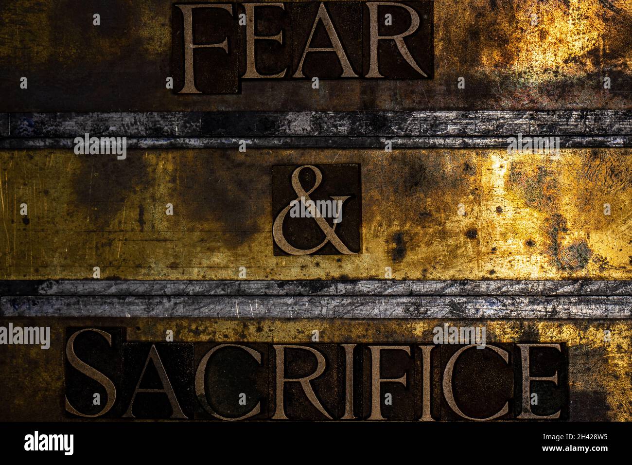 Fear and Sacrifice text on textured grunge copper and vintage gold background Stock Photo