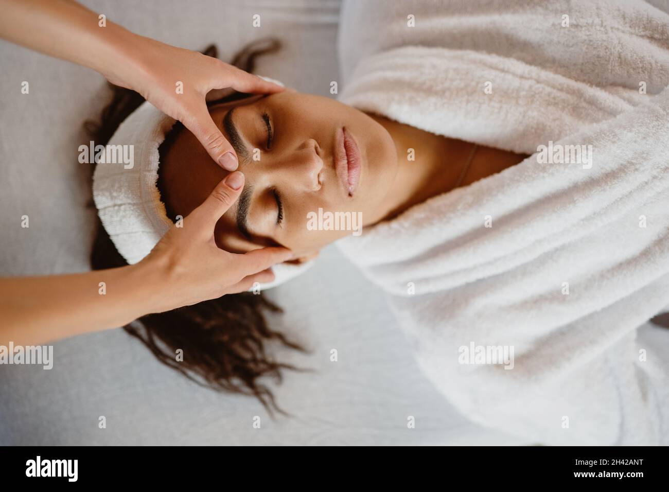 Top view of young African American woman getting a face treatment at spa salon. Stock Photo