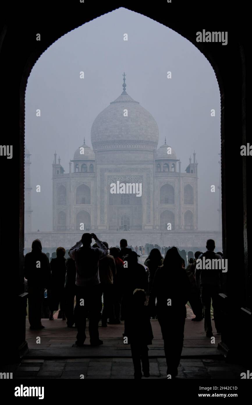 People standing at the gate to Taj Mahal complex in early morning, Agra, Uttar Pradesh, India. Taj Mahal was designated as a UNESCO World Heritage Sit Stock Photo