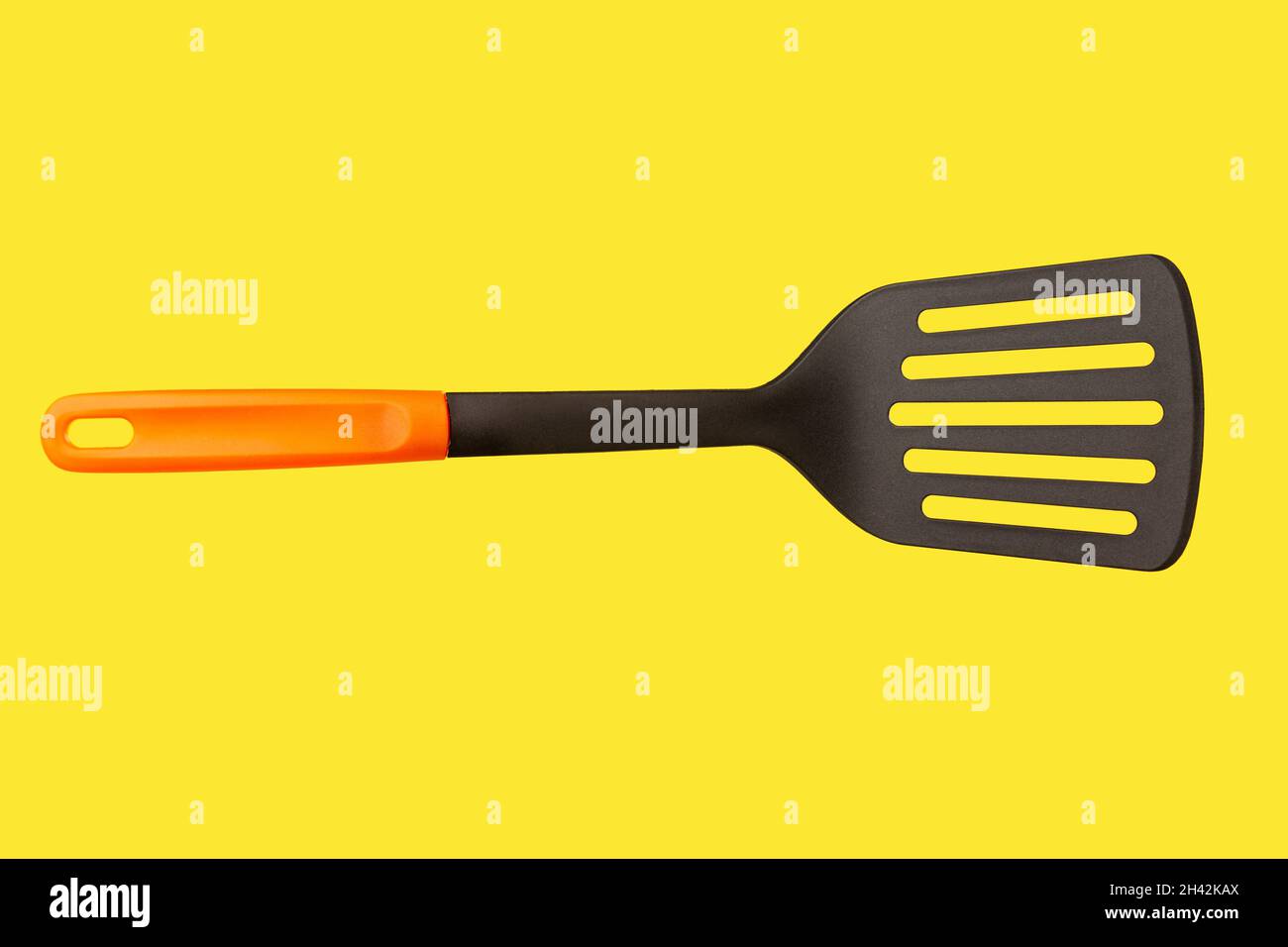 A black plastic spatula with orange handle Stock Photo