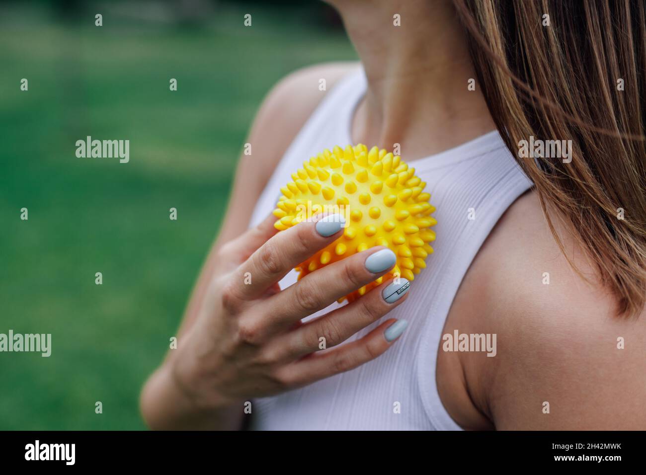 attractive young woman use spiky massage ball to tighten skin and