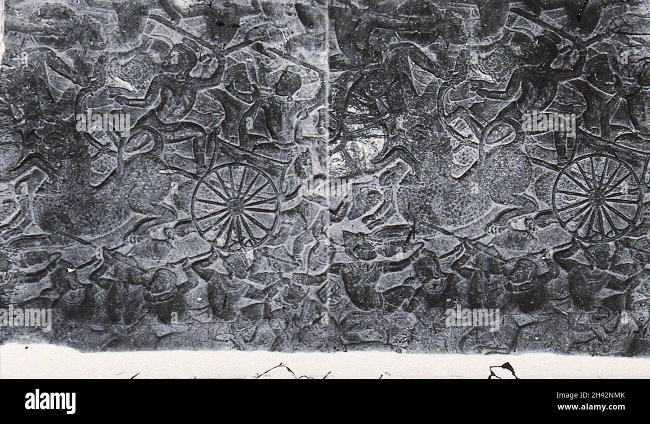 Bas-relief panel from the Mahabharata of a battle scene. A furious melée with chariots, horses, men and monkeys [? or demons]. Nakhon Thom [Angkor Wat], Cambodia. Stock Photo
