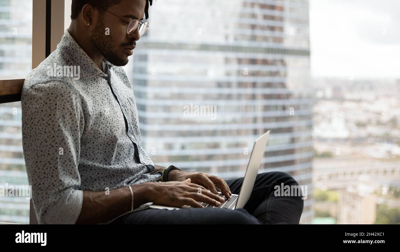 Happy creative african hipster man working on computer. Stock Photo
