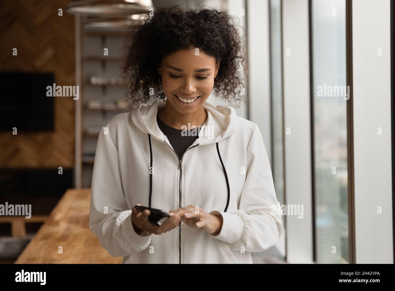 Smiling young african american woman using cellphone Stock Photo - Alamy