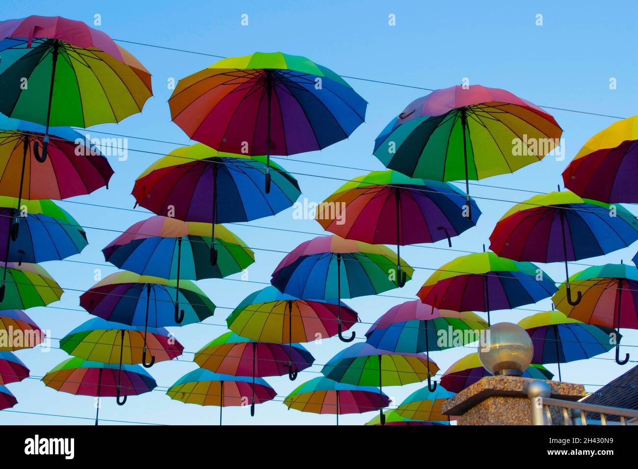 Many colorful umbrellas hang in the sky above the cafe. Decorating ...