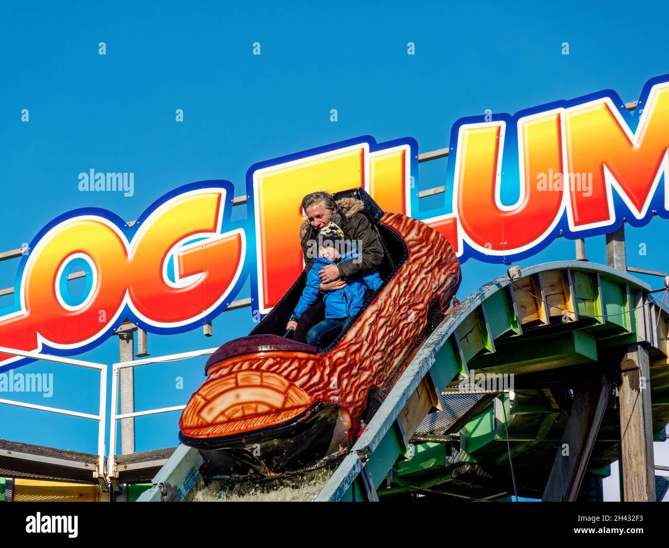 log flume water ride at the fun fair man and child on the ride Stock Photo