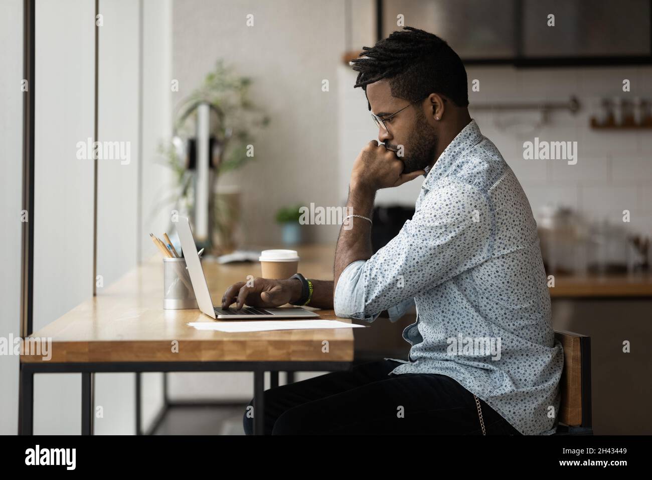 Thoughtful young mixed race businessman working on computer. Stock Photo
