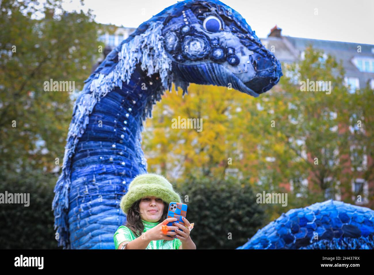 Grosvenor Square, London, UK. 31st Oct, 2021. People look at and pose with  Messy the COP NESS Monster. Messy is made entirely out of recycled jeans  and other sustainable materials, and will