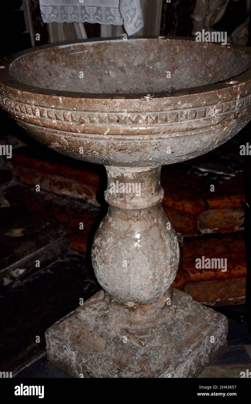 Classic baptismal font,made of a stone of granite, used for baptism in a catholic church Annunciation of the Blessed Virgin Mary in Mali Losinj. Stock Photo