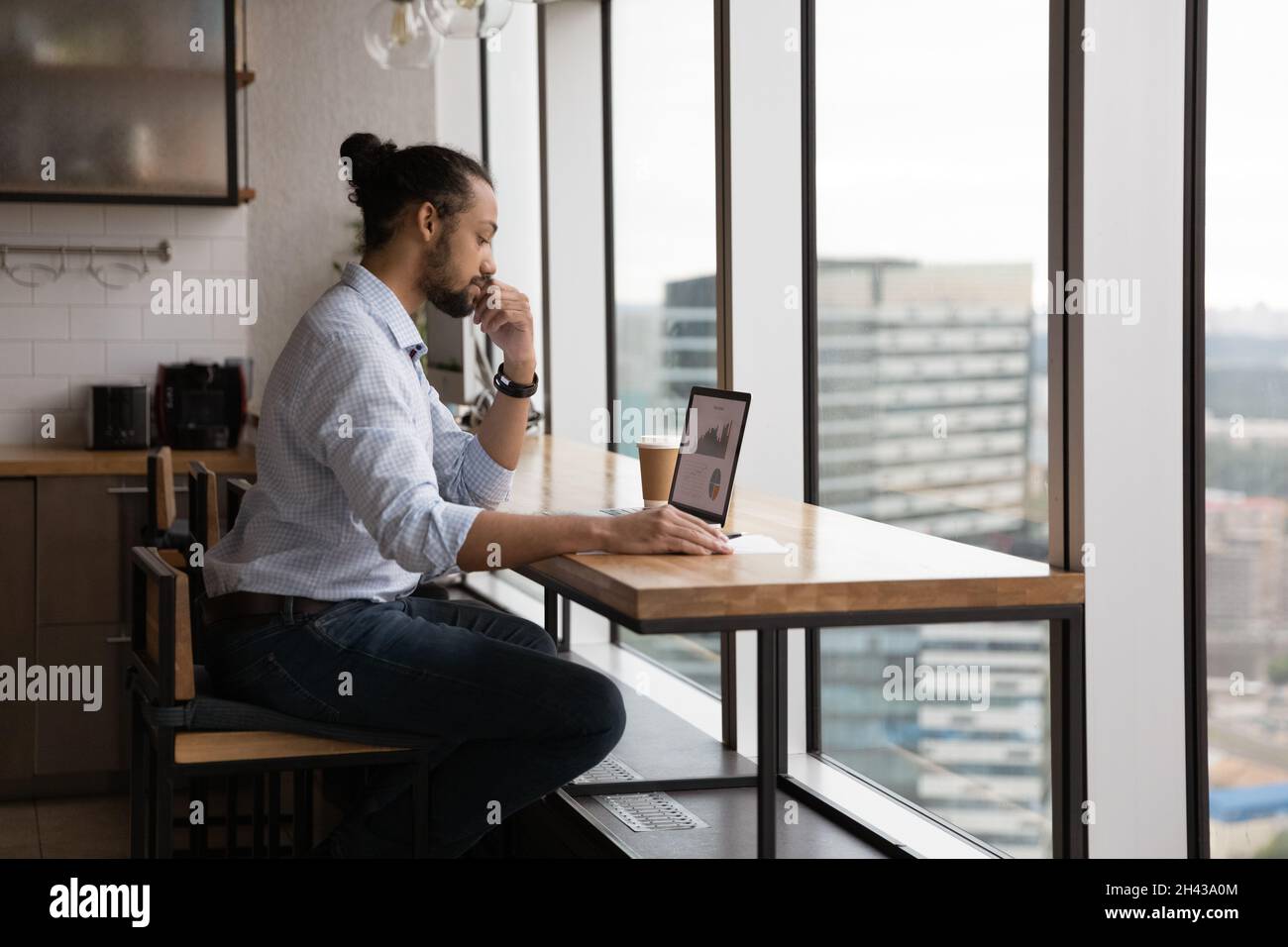 Concentrated young african american businessman analyzing online sales. Stock Photo