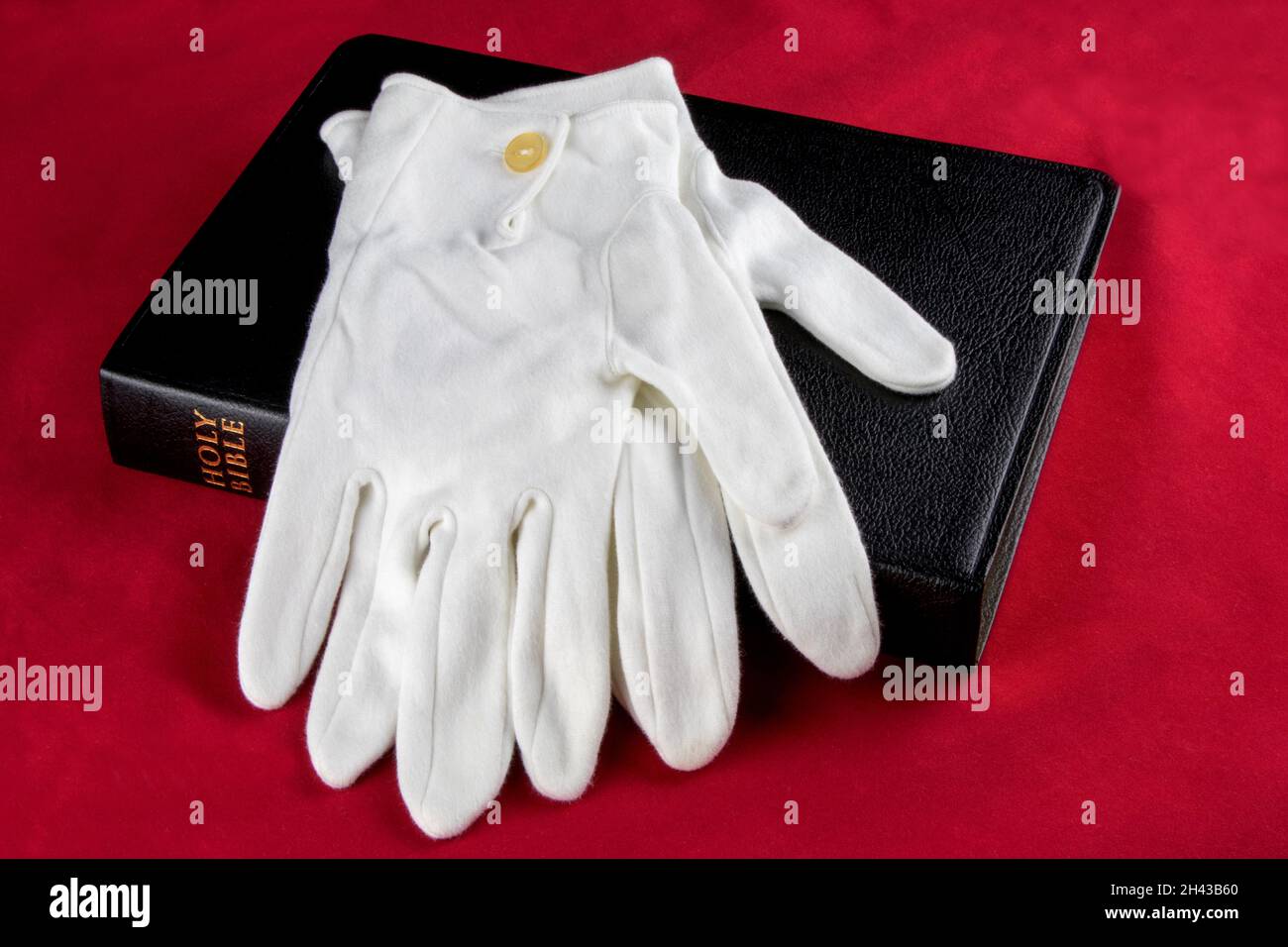White gloves and bible isolated on a red background Stock Photo Alamy