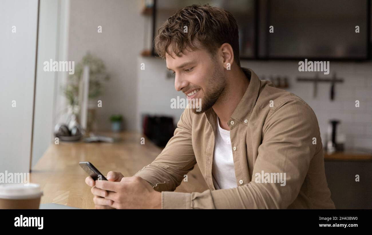 Happy handsome young man using cellphone apps. Stock Photo