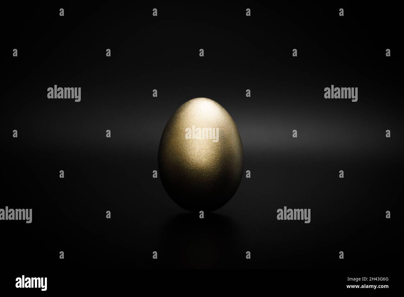 Golden egg against black background Stock Photo