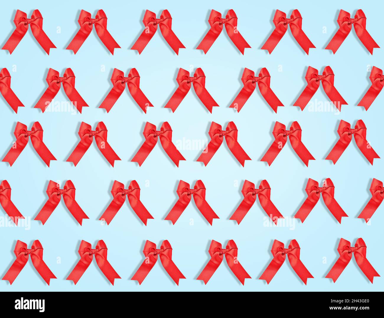Many red bows on light blue background. Pattern for design Stock Photo