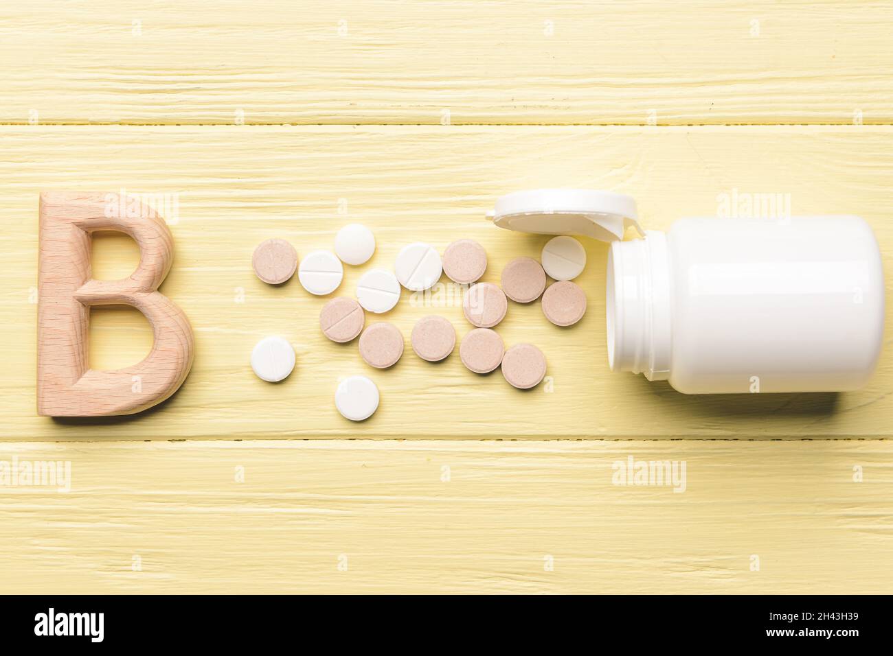 Vitamin B pills on color wooden background Stock Photo