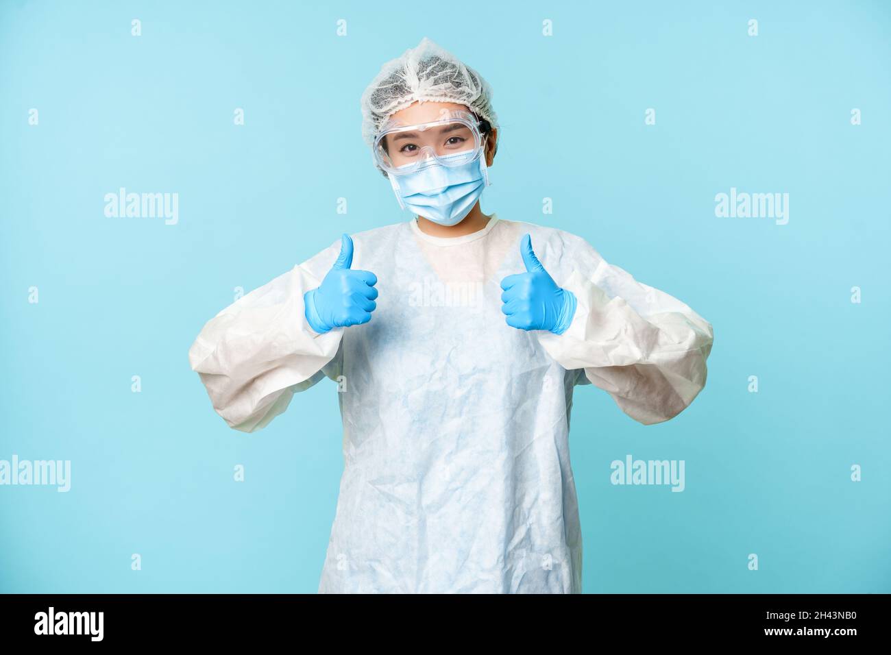 Optimistic asian nurse or doctor, wearing personal protective equipment ...