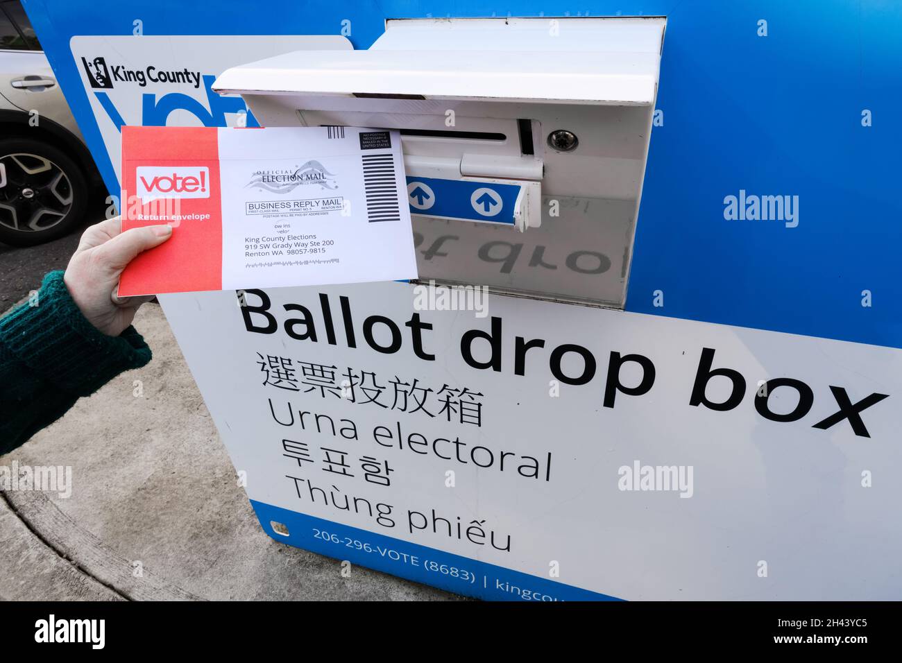 Duvall, WA, USA  - October 30, 2021; Voter depositing mail ballot into curb side drop box in King County, Washington State for upcoming election Stock Photo