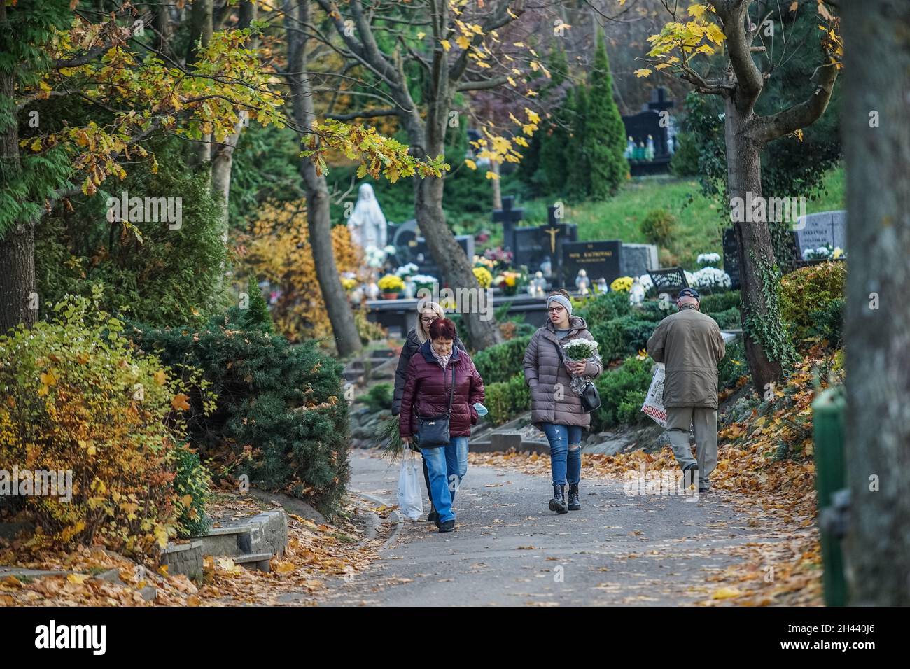 Gdansk, Poland 31st, Oct. 2021 People visiting graves of their relatives at the Lostowicki Cemetery are seen. Christian people celebrate All Saints Day (Wszystkich Swietych), pay respect to the dead family members, lay flowers and lit candles on their graves. All Saints' Day on 1 November and All Souls' Day on 2 November are when millions of Poles visit the graves of loved ones, often travelling hundreds of kilometres to their home towns. In 2021 as the 1st Nov is on Monday many of people visit graves on the weekend preceding that day. (Photo by Vadim Pacajev/Sipa USA) Stock Photo