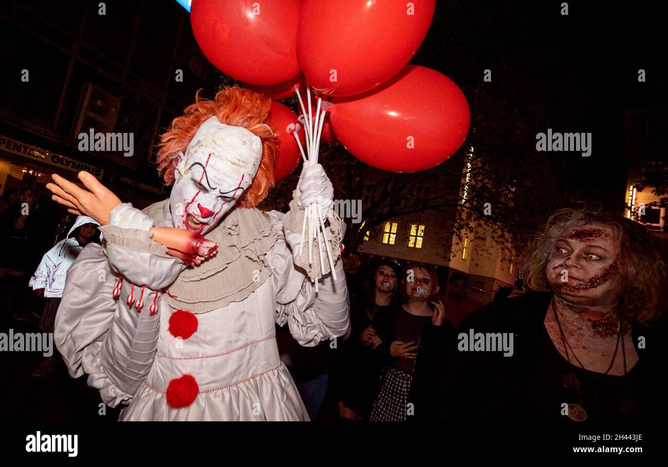 https://c8.alamy.com/comp/2H443JE/essen-germany-31st-oct-2021-clown-pennywise-from-the-novel-it-by-stephen-king-bites-a-torn-off-hand-after-a-years-break-from-corona-several-hundred-people-dressed-up-again-this-year-for-the-halloween-zombiewalk-through-the-city-credit-malte-krudewigdpaalamy-live-news-2H443JE.jpg