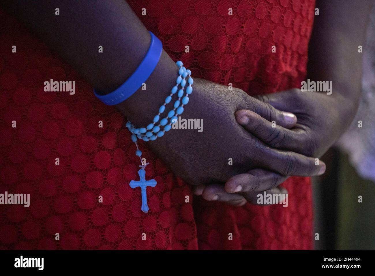 A rosary hangs from the wrist of a worshipper as she takes part in Sunday Catholic Mass at the Chapelle de l'Immaculee Conception de l'HUEH in Port-au-Prince, Haiti October 31, 2021. REUTERS/Adrees Latif Stock Photo