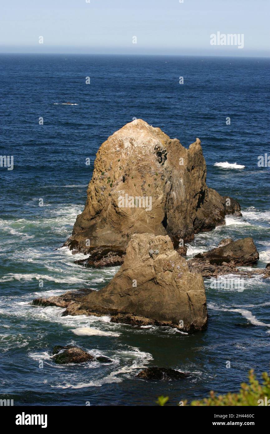 Large volcanic rocks surrounded by turbulent sea water on the coast of California Stock Photo