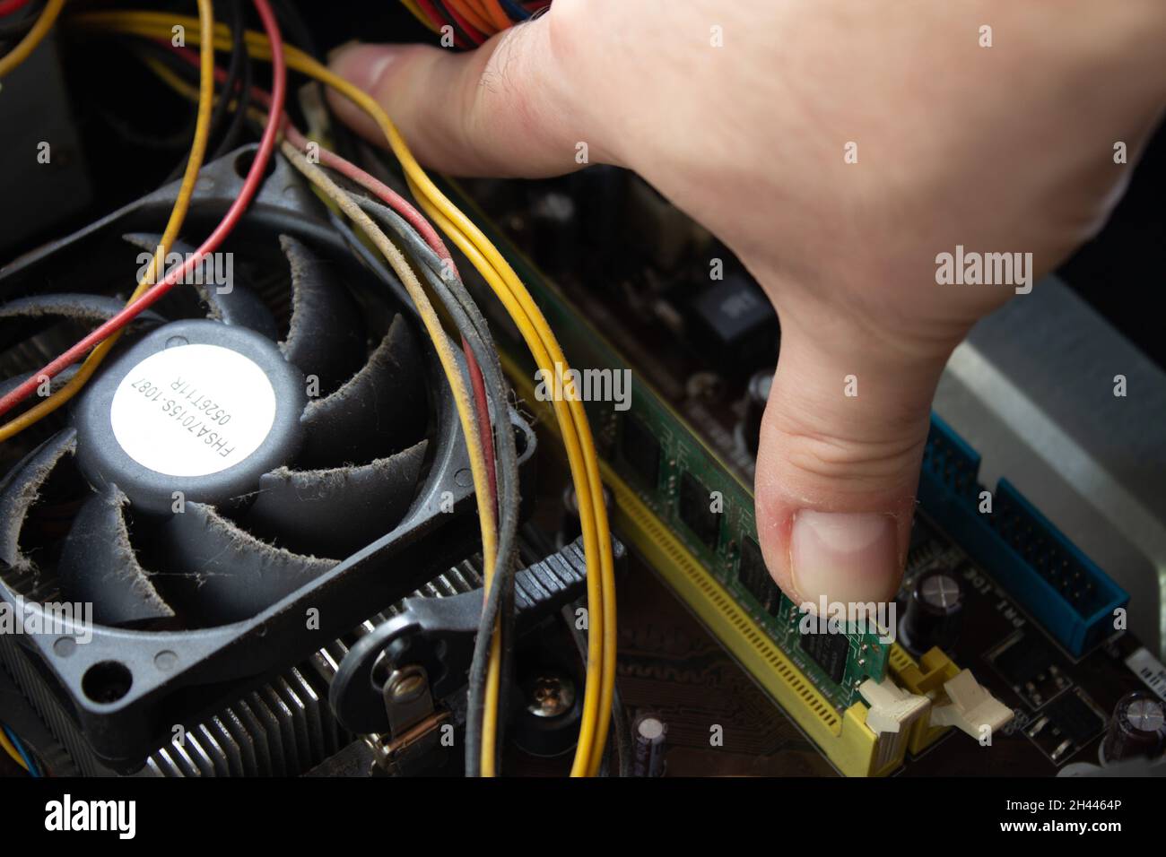 Man hand pushing a ram into its socket to make the computer work again with normal functions. Stock Photo