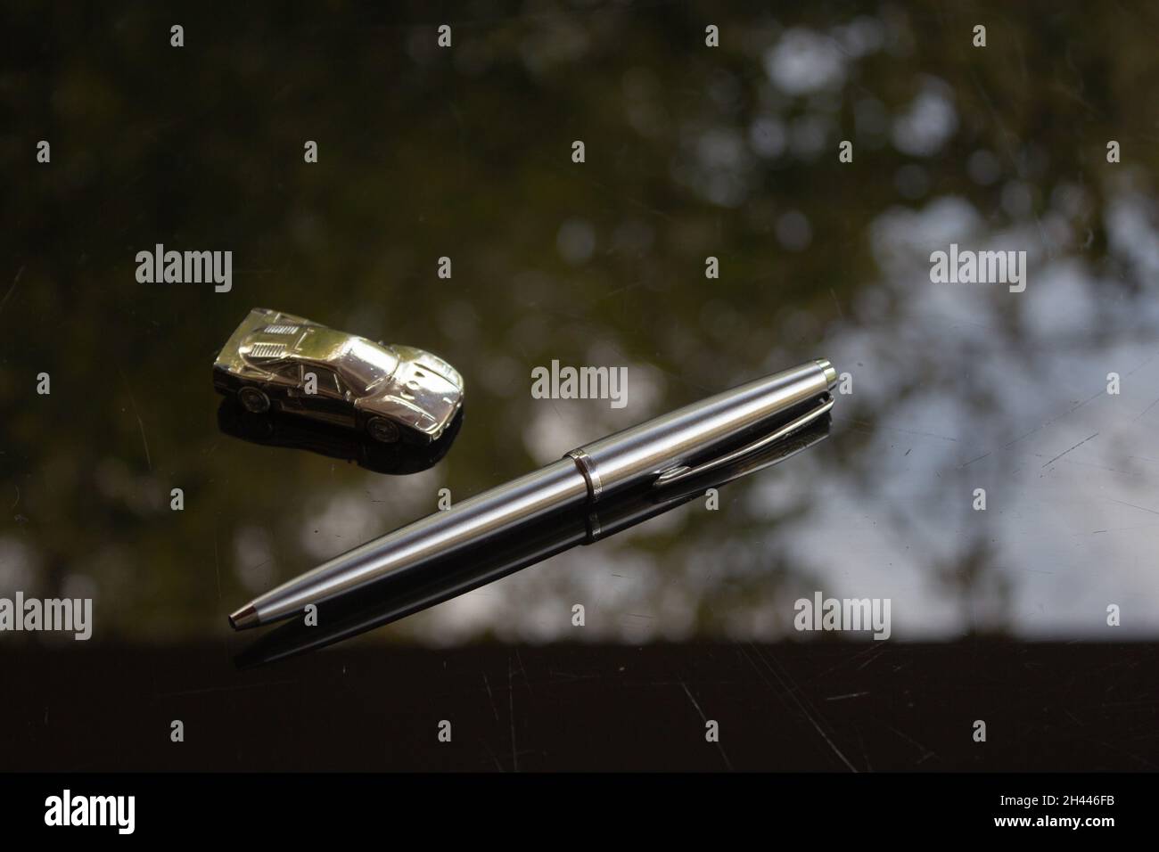 A shiny silver pen on a black surface. Stock Photo