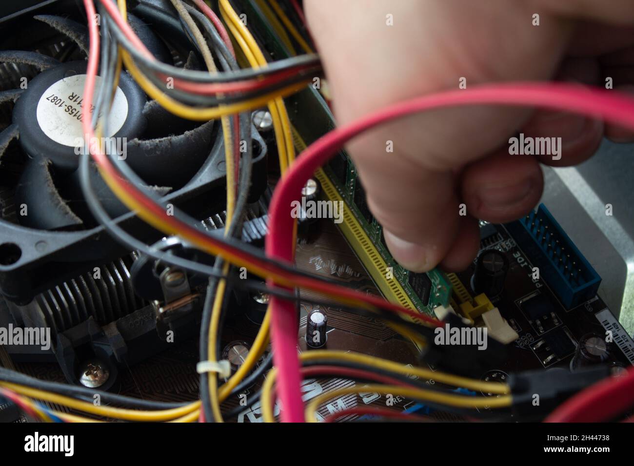 Man hand pushing a ram into its socket to make the computer work again with normal functions. Stock Photo