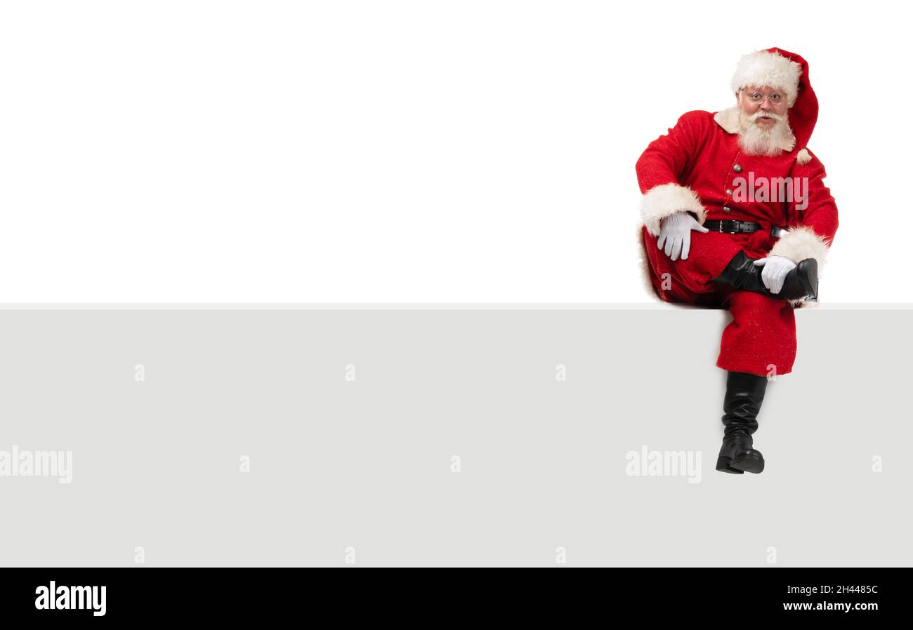 Santa Claus sitting on a blank panel isolated on white background Stock ...