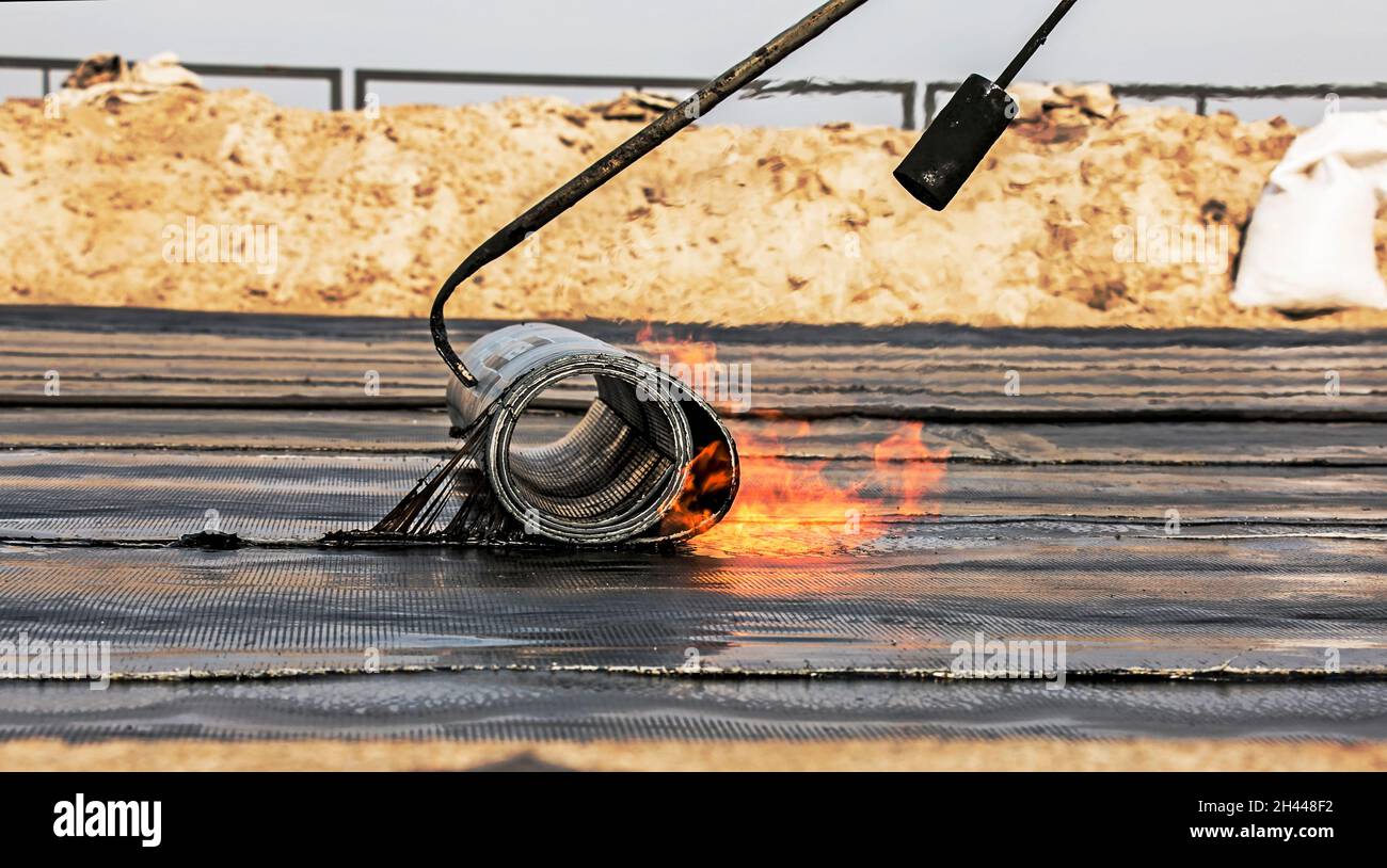 The process of installing roofing material using a blowtorch. The