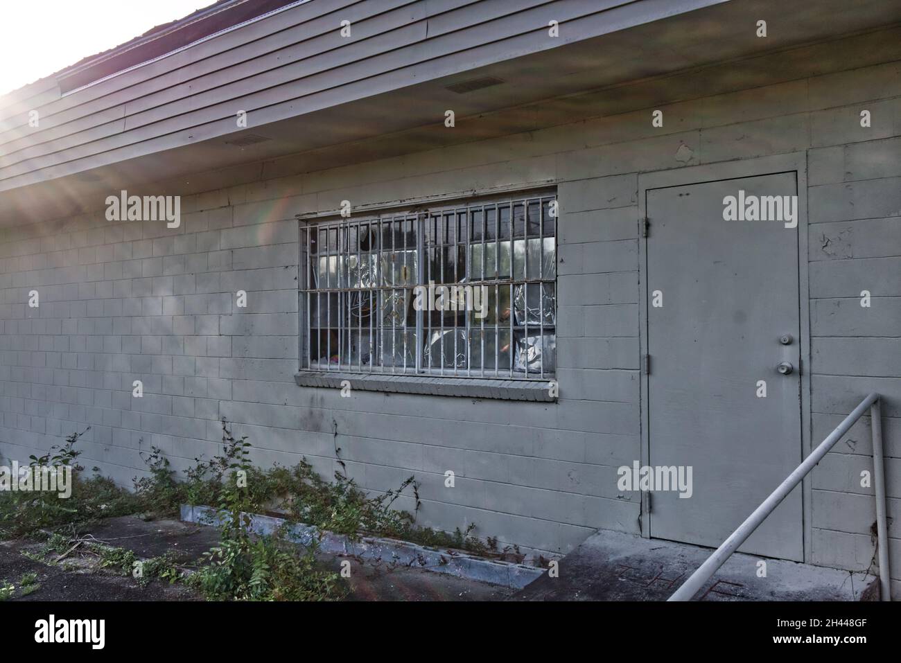 Old vintage white brick building abandoned gated windows angled view ...