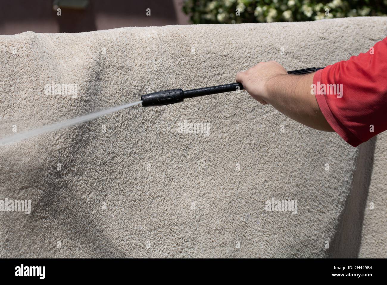 Washing carpets with high pressure washer. Cleaning the carpet with a gun for washing high