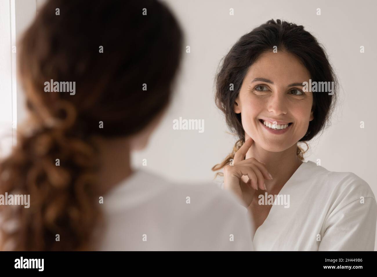 Beautiful woman admire face view looking in mirror Stock Photo