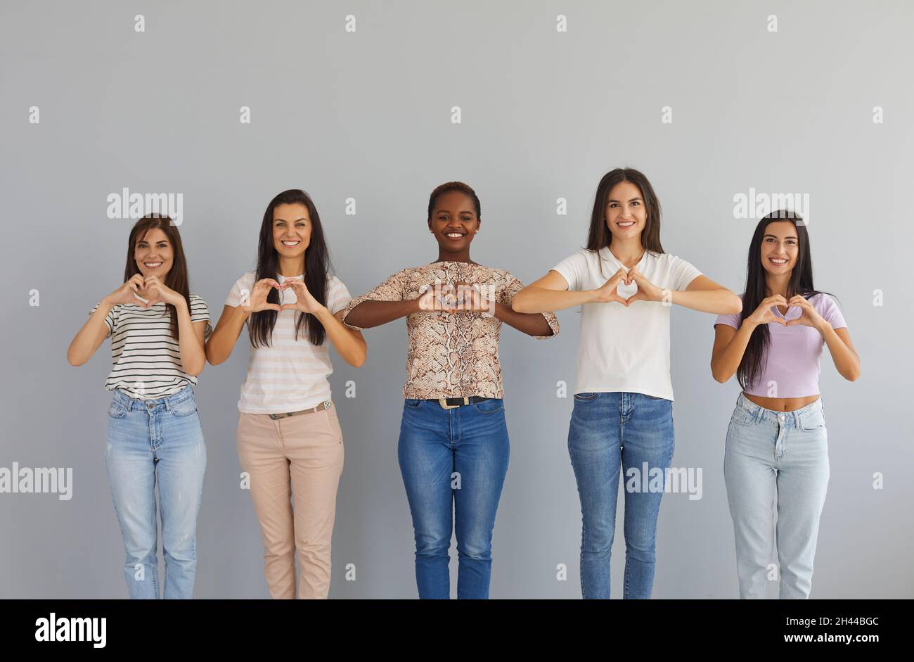 Diverse group of happy smiling young women standing together and doing ...