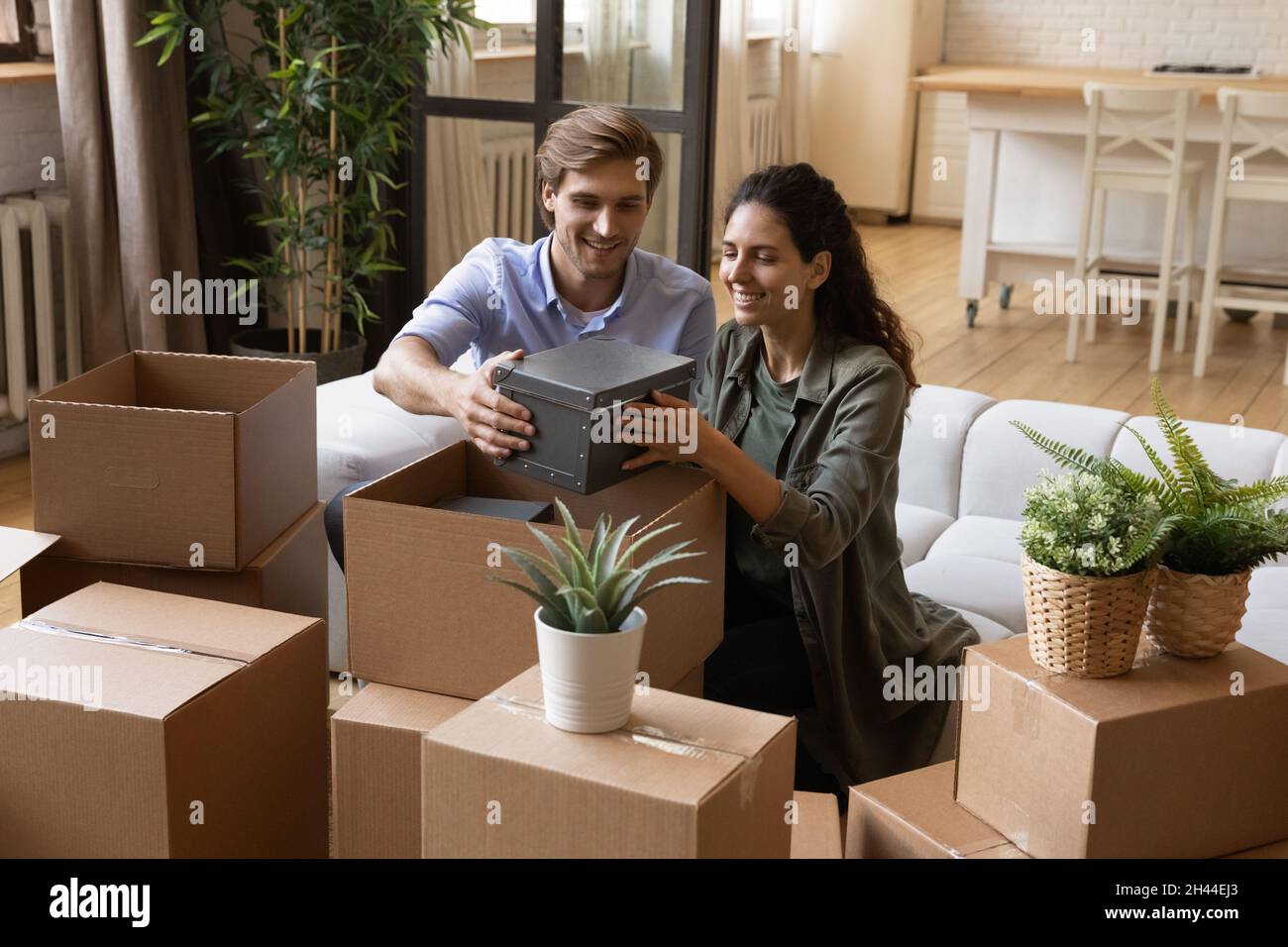 Beautiful couple taking out belongings from boxes at relocation day Stock Photo