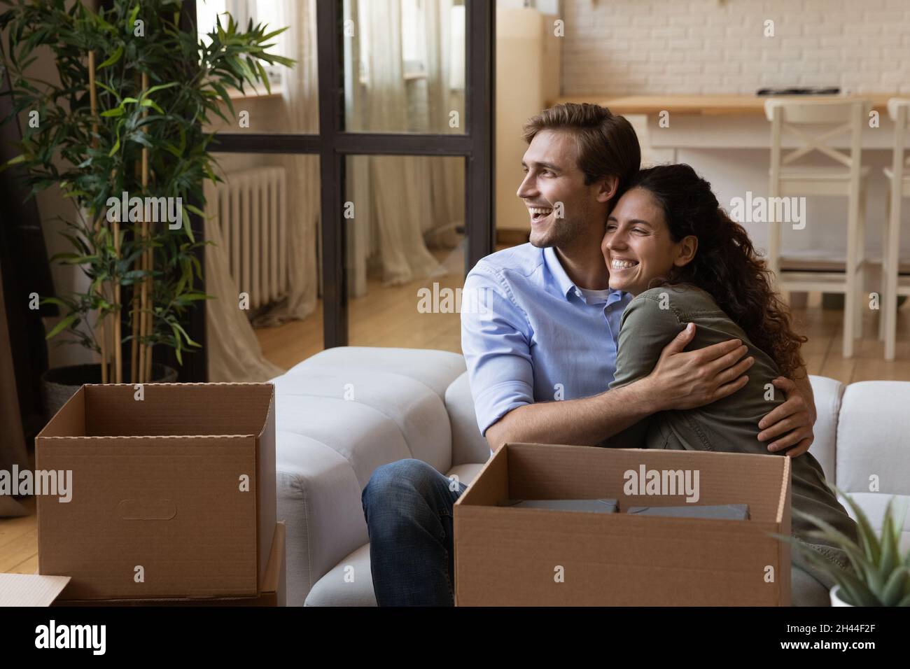Happy married couple resting on sofa on moving day Stock Photo