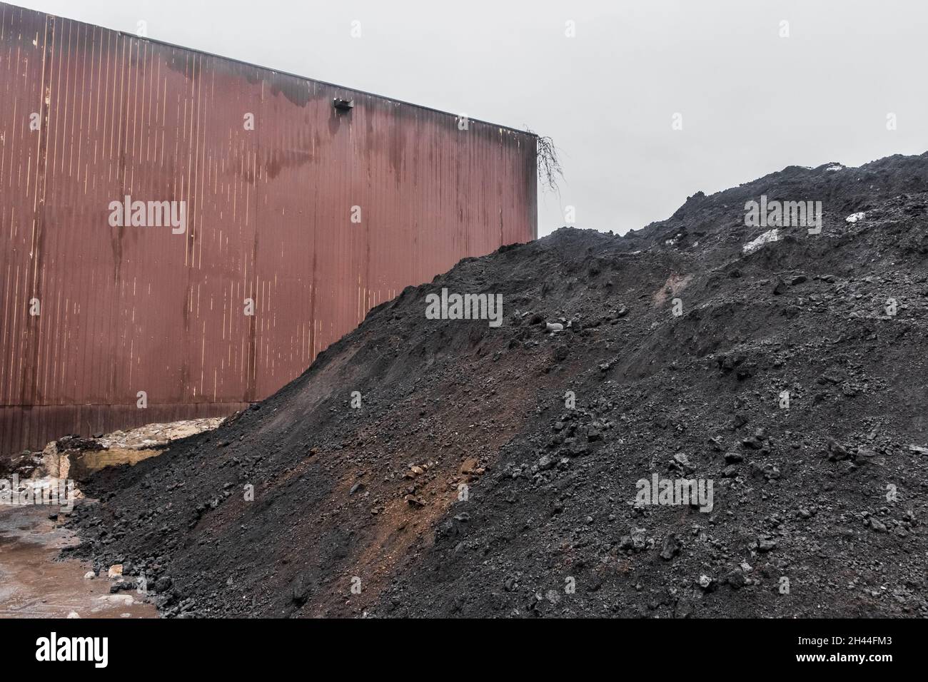 Large pile of dark or black coal slag in the open air of the industrial