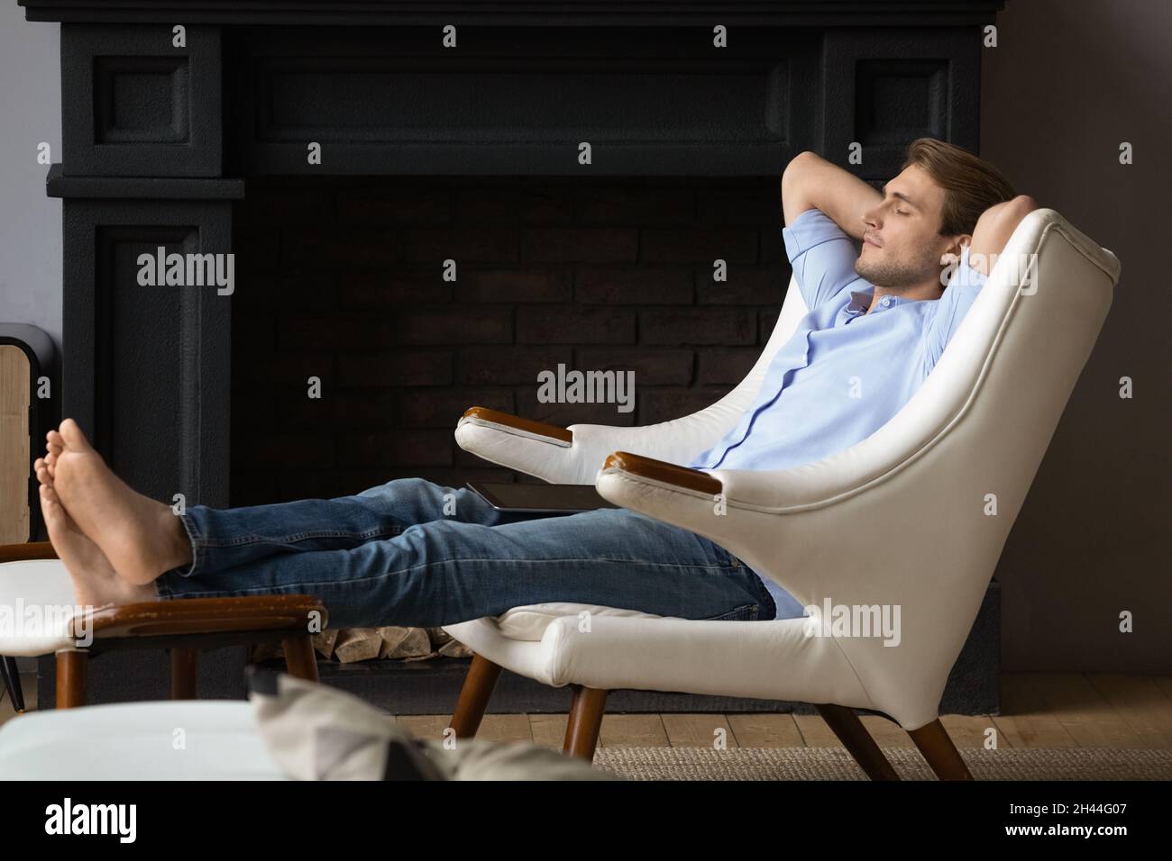 Serene man put feet on footstool relaxing in armchair Stock Photo Alamy