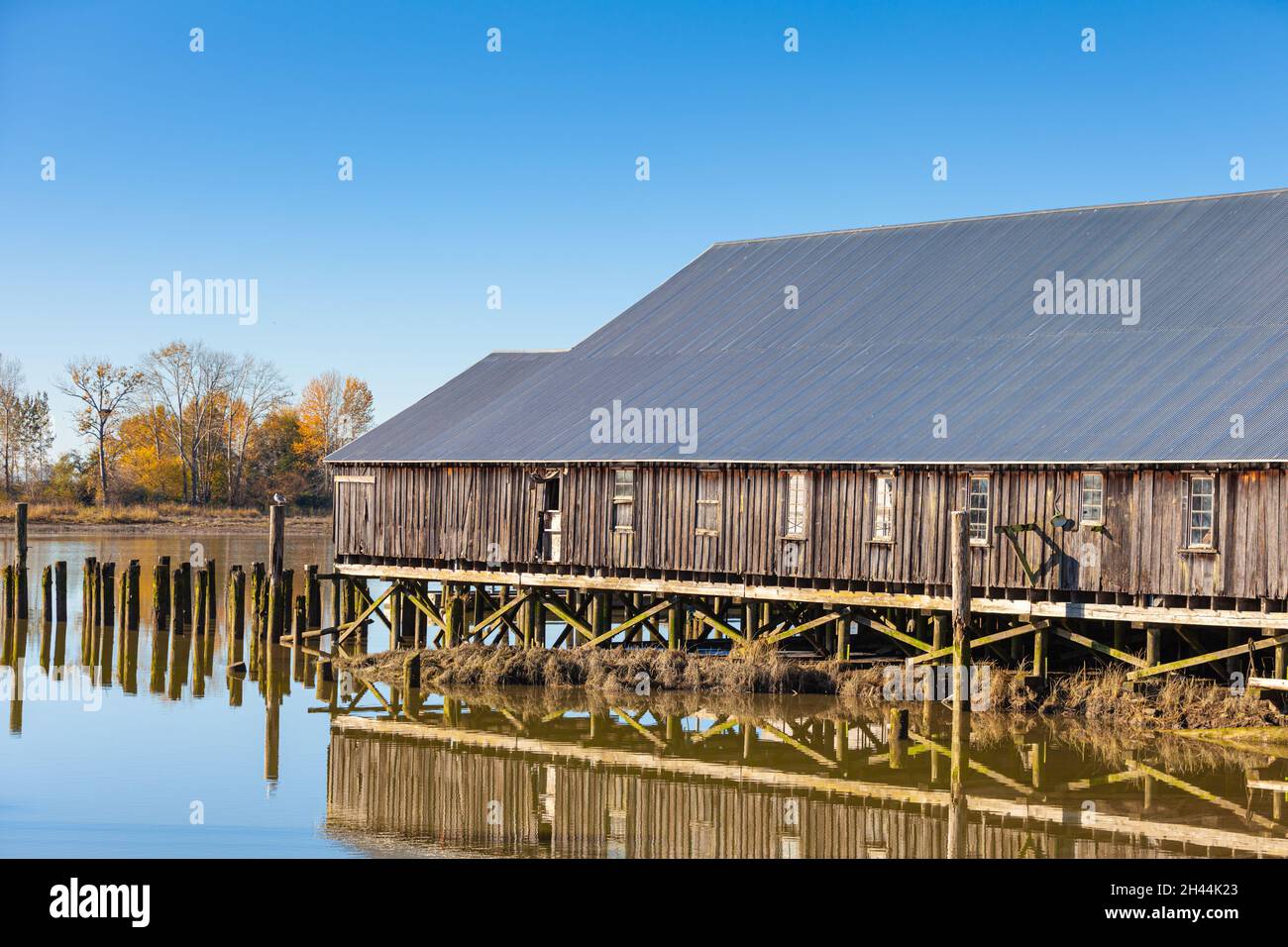 Reflection of the Britannia Ship Yard in calm water at low tide in Steveston British Columbia Canada Stock Photo