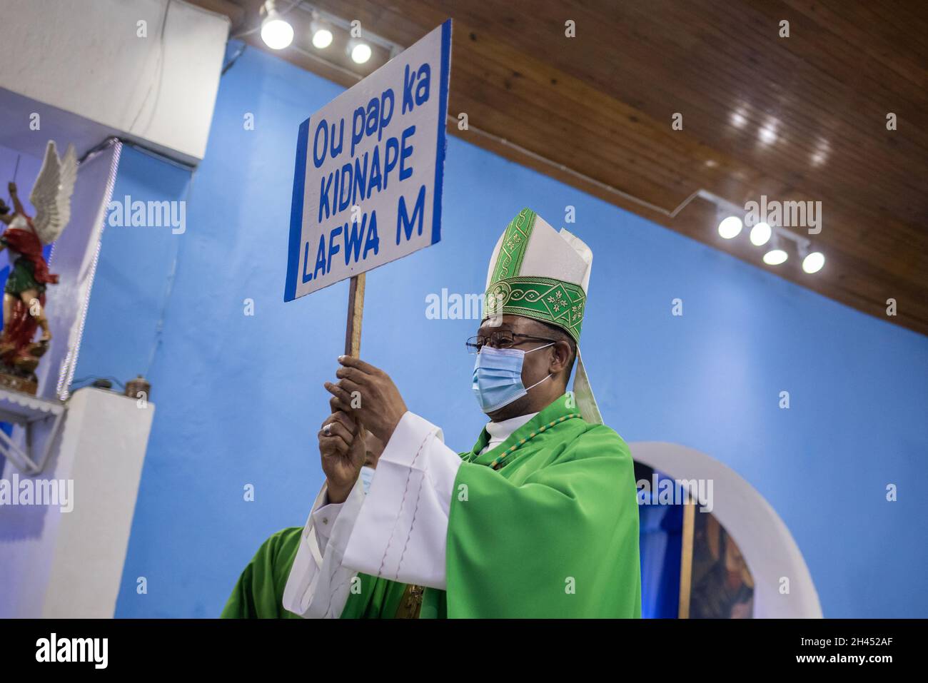 Max Leroy Mesidor, the Metropolitan Archbishop of Port-au-Prince, holds a placard that reads 'You cannot kidnap my faith', which he received as an offering from worshippers during Sunday Catholic Mass at the Chapelle de l'Immaculee Conception de l'HUEH in Port-au-Prince, Haiti October 31, 2021. REUTERS/Adrees Latif Stock Photo