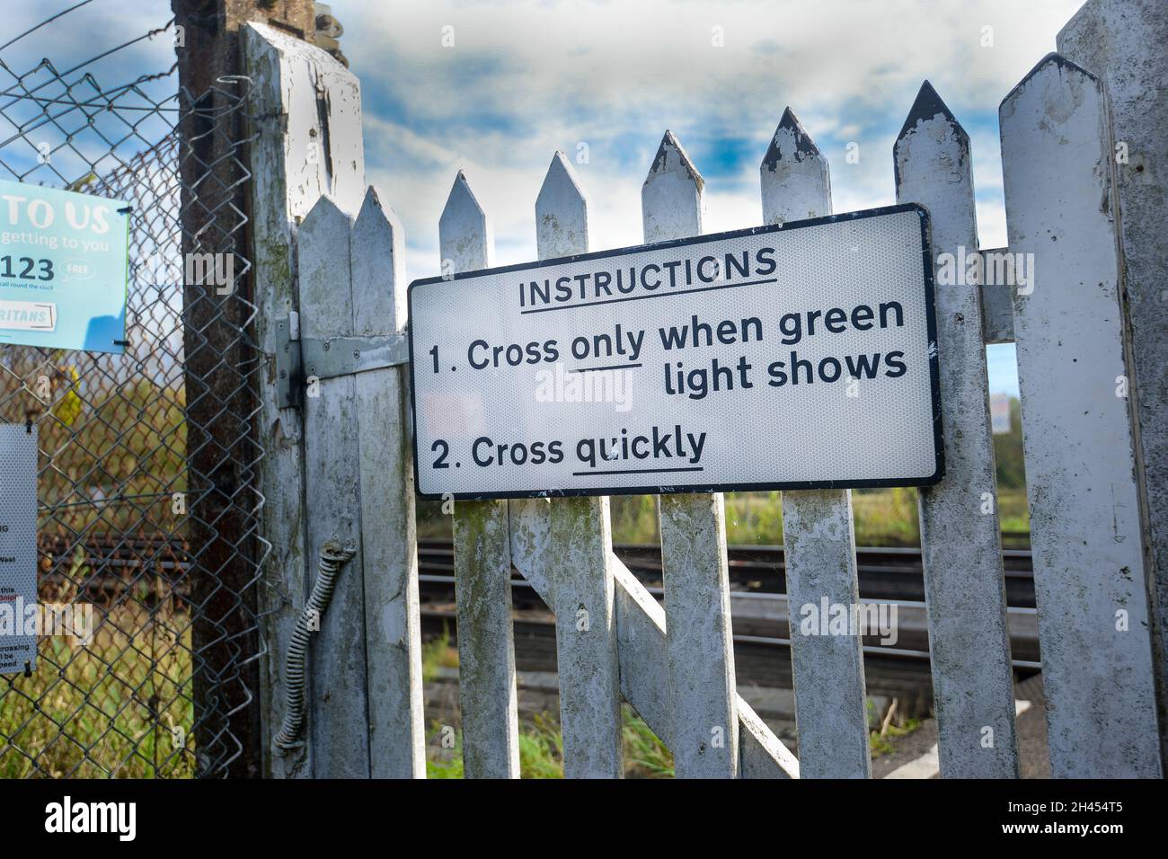 Railway crossing pedestrian warning sign advising when is safe to cross  Stock Photo