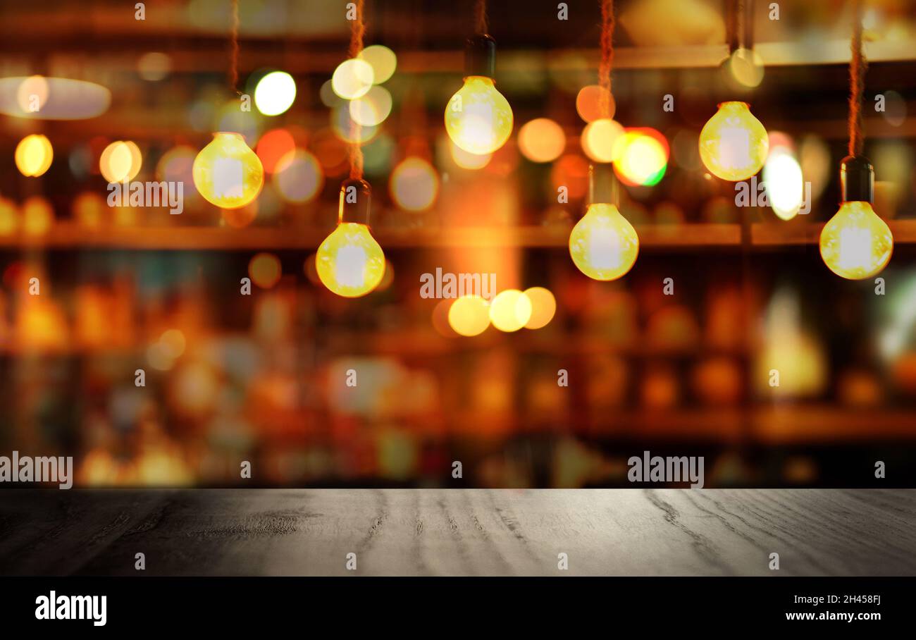 top of black wood table with small round lamp light of blur pub or bar