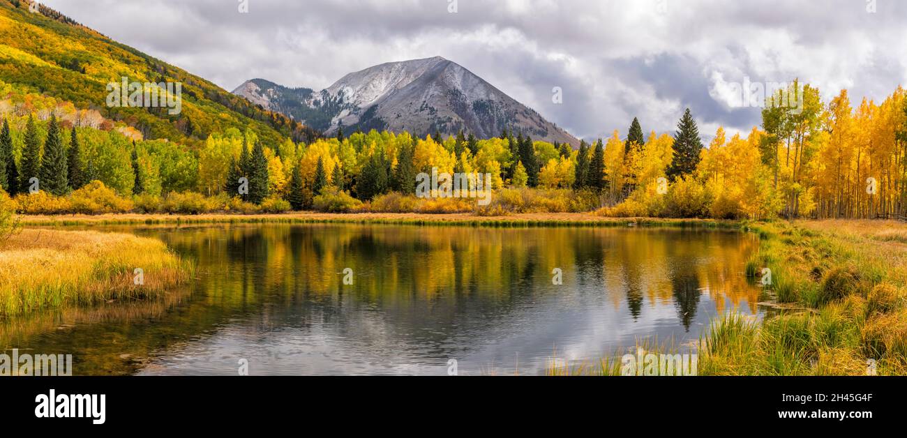 Sunlit Autumn color reflected in Warner Lake in the Manti-La Sal National Forest below Haystack Mountain near Moab, Utah. Stock Photo